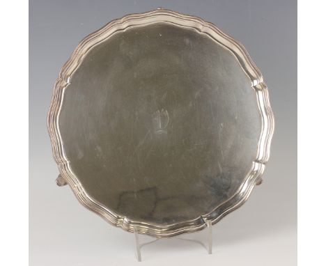 An Edward VIII silver circular salver, initial engraved within a raised piecrust rim, on scroll legs, Chester 1936 by S. Blan