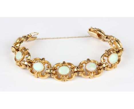 A 9ct gold and opal bracelet, collet set with a row of oval opals within pierced scroll decorated links, on a snap clasp, Lon