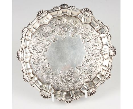 A George III silver circular card salver, the centre engraved with flowers and scrolling leaves within a raised rim cast with