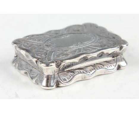 A Victorian silver shaped rectangular vinaigrette, engraved with leaves and scrolls, the hinged lid revealing a gilt pierced 