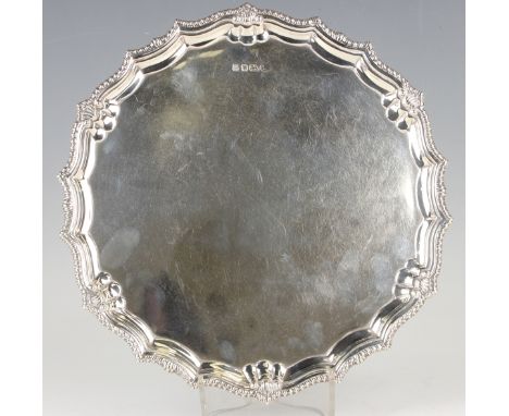 An Elizabeth II silver circular salver with scallop and gadrooned rim, on three paw feet, Sheffield 1978 by Barker Ellis Silv