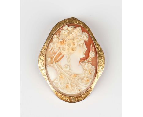 A late Victorian gold mounted oval shell cameo brooch, carved as the portrait of a lady within a scroll engraved border, unma