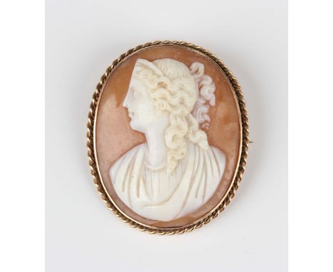 A late Victorian gold mounted oval shell cameo brooch, carved as a portrait of a classical lady within a ropetwist border, de