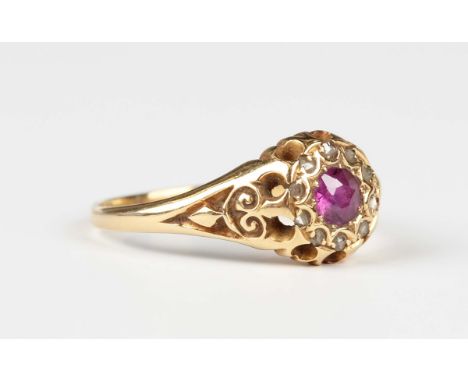 An Edwardian gold, ruby and diamond cluster ring, with scroll decorated shoulders, partial mark, weight 3.7g, ring size appro
