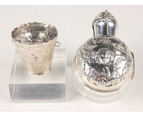 A late Victorian silver perfume bottle holder, the hinged lid and sides embossed with amorini amongst scrolls, fitted with a 