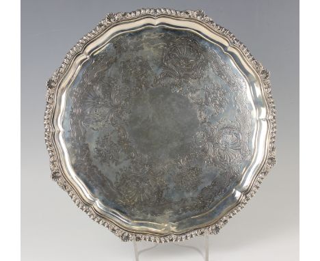 A late Victorian silver circular salver, the centre engraved with scallop shells and flower charged urns within a cast gadroo