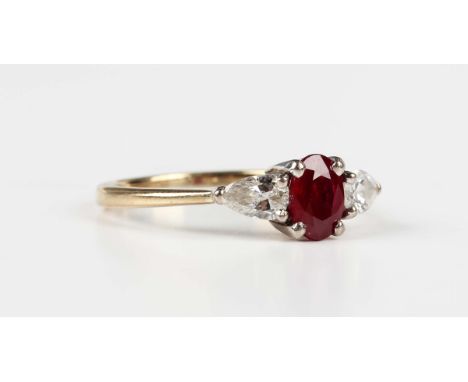 A 9ct gold ring, claw set with an oval cut ruby between two pear shaped diamonds, weight 3.2g, ring size approx O1/2.Buyer’s 