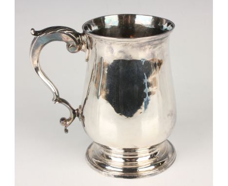 A George III silver tankard of baluster form with foliate capped scroll handle, on a stepped circular foot, London 1786 by He