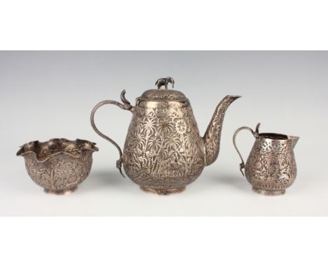 A 19th century Indian silver three-piece tea set, comprising teapot, milk jug and sugar bowl, each piece decorated in relief 