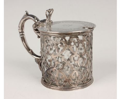 A Victorian silver cylindrical mustard, the hinged lid engraved with a foliate scroll border above pierced strapwork sides, f