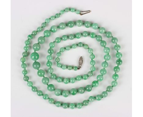 A single row necklace of graduated jade beads on a diamond set marquise shaped clasp, length 87cm.Buyer’s Premium 29.4% (incl