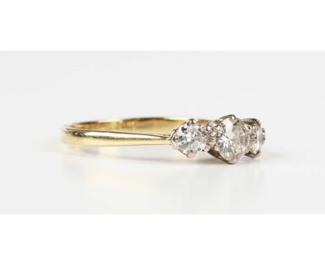 A gold and diamond three stone ring, claw set with a row of circular cut diamonds, the principal diamond mounted to the centr