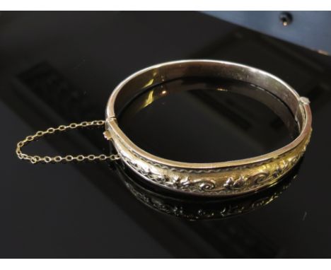 A 9ct gold stiff hinge bangle with embossed decoration 15.9g
