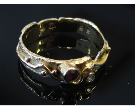 A gold ruby and diamond set dress ring with wavy design, stamped 750, size K/L, 3.3g