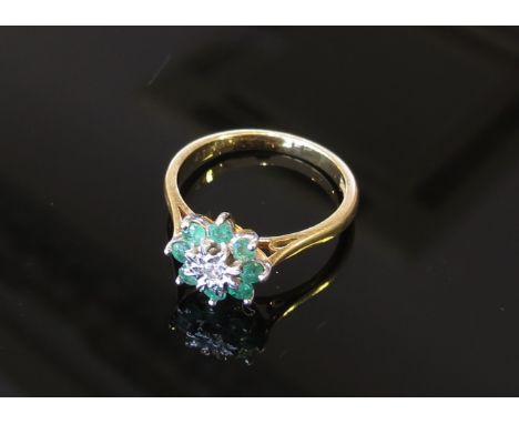 An emerald and diamond daisy ring, stamped 18ct, size M/N, 3.4g