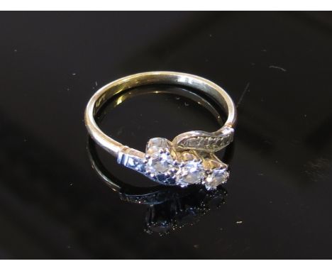 A gold three stone diamond crossover ring, stamped 18ct and Plat, size P/Q, 3.1g