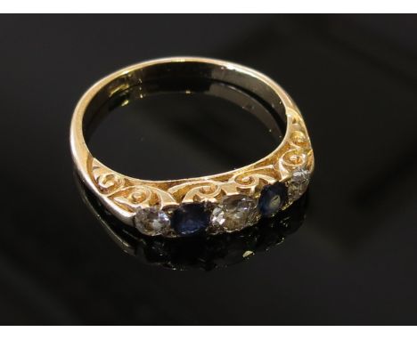 An 18ct gold diamond and sapphire ring, the central diamond flanked by smaller sapphires and diamonds in turn, size Q, 3.5g