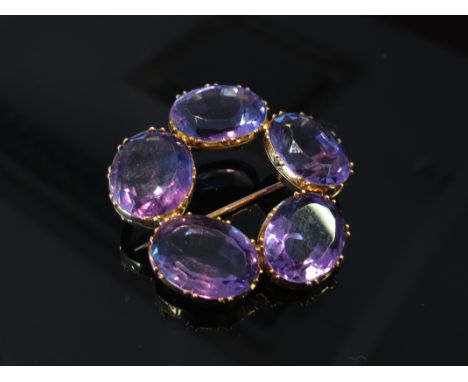 An amethyst brooch with five oval amethysts in a circle, each stone 16mm x13mm