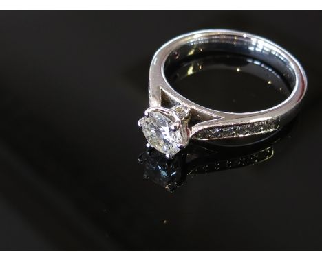 A platinum diamond solitaire ring with diamond set shoulders, size K, 5.1g