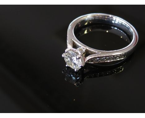 A platinum diamond solitaire ring with diamond set shoulders, size K, 5.1g