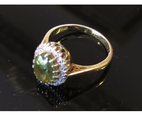 A gold diamond and green stone ring stamped 18ct, size O, 4.4g