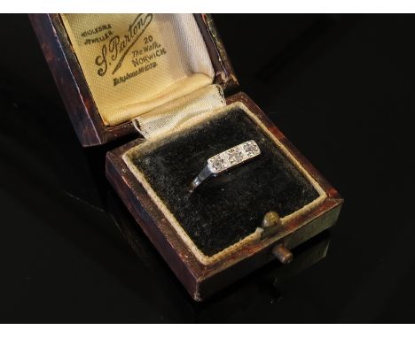 A gold ring set with three diamonds in square mounts, stamped 18ct and Plat, size N, 1.9g