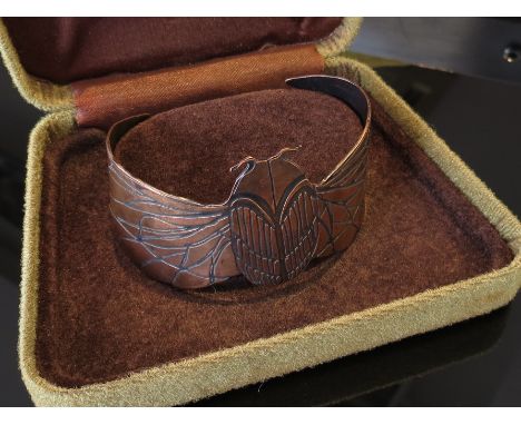 An Art Nouveau copper dragonfly bangle with ornate decoration 