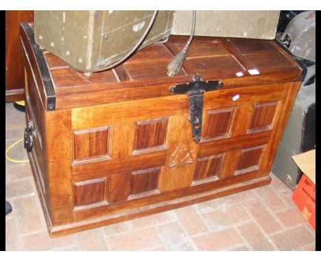 A dome top teak storage trunk with metal handles and lock, having carved Masonic sign to the front 