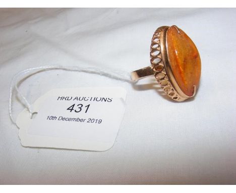 A lady's oval amber dress ring in gold setting 