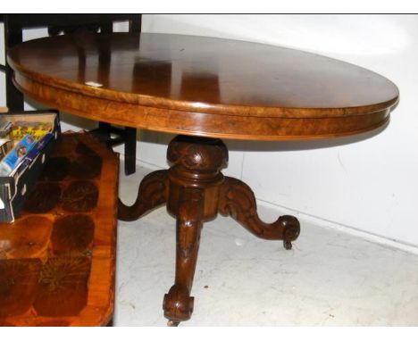 A circular walnut table on carved tripod support - diameter 120cm 