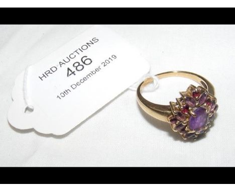 A lady's purple stone dress ring in gold mount 