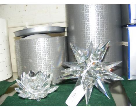 A boxed Swarovski 'water lily' candlestick holder, together with a boxed Swarovski star shaped candle holder 