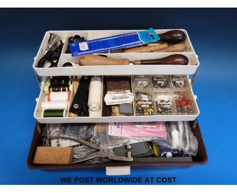 A tool box containing a quantity of leatherwork tools