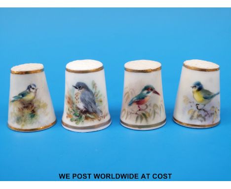 Four Royal Worcester thimbles hand decorated with birds, all signed Powell and with puce marks (tallest 2.5 cm)
