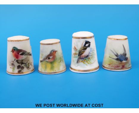 Four Royal Worcester thimbles hand decorated with birds, all signed Powell and with puce marks (tallest 2.5cm)