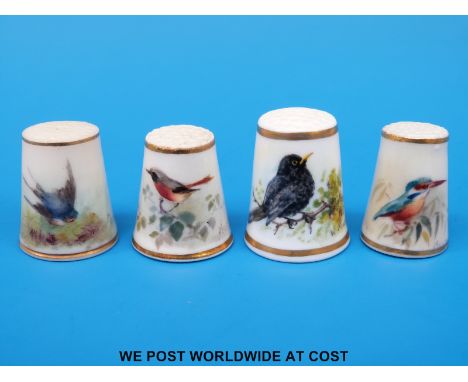Four Royal Worcester thimbles hand decorated with birds, all signed Powell and with puce marks (tallest 2.5 cm)