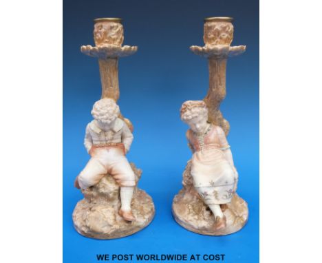 A pair of c1880's Royal  Worcester blush ivory Kate Greenaway figural candlesticks in the form of a young boy & girl resting 