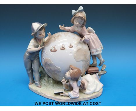 A Lladro figural group of three children studying a large globe (23cm tall)