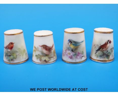 Four Royal Worcester thimbles hand decorated with birds, all signed Powell and with puce marks (tallest 2.5 cm)