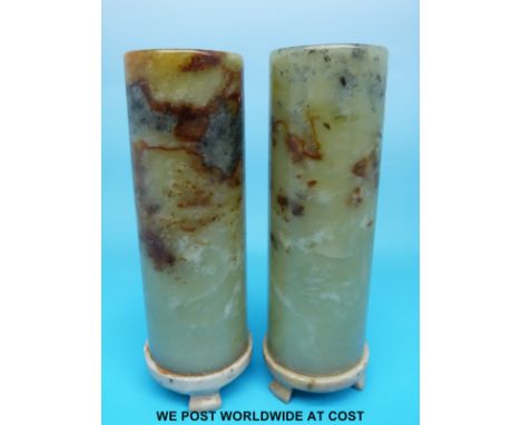 A pair of Chinese jade or hardstone vases of cylindrical form raised on carved bases with scrolling feet (15.5cm tall)