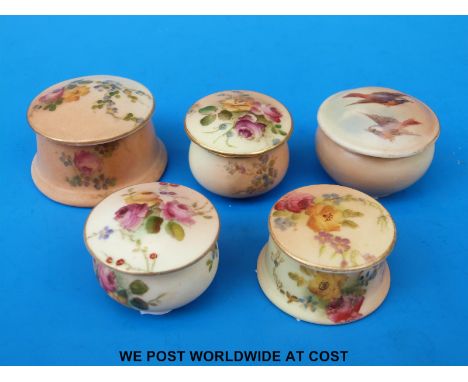 Four Royal Worcester blush ivory circular pill boxes decorated with flowers together with another decorated with birds in fli