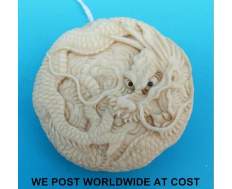 A carved ivory Japanese button of a dragon