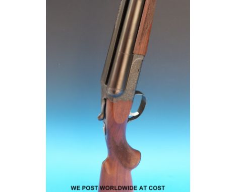 SKB 12 bore double barrelled side by side shotgun with ornate engraving to the locks and chequered semi-pistol grip, in hard 
