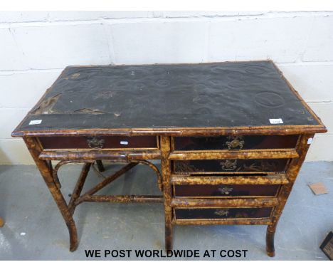A oriental bamboo ladies desk with five drawers with decorative wooden panel to the rear and applied decoration to the event 