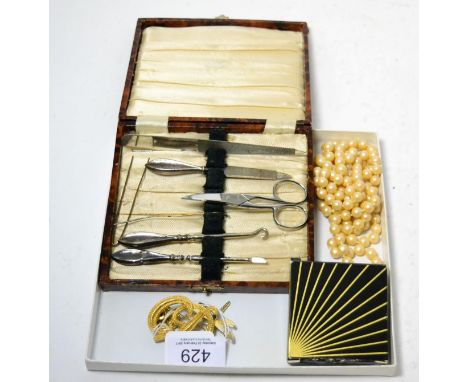A Christian Dior brooch, a simulated pearl necklace, two other brooches and a manicure set 