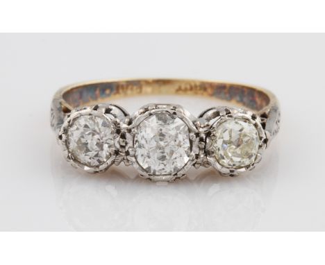 An 18ct yellow gold diamond three stone ring, illusion set with three old cut diamonds graduated in size in a platinum settin