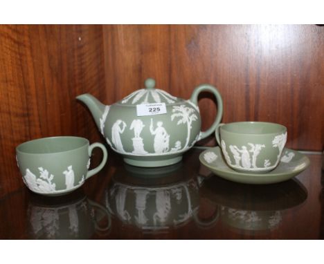 A GREEN WEDGWOOD JASPERWARE TEAPOT, TOGETHER WITH TWO TEACUPS AND ONE SAUCER 