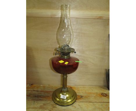 A VINTAGE BRASS AND RUBY GLASS OIL LAMP
