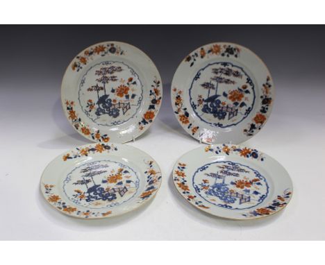 A group of four Chinese Imari export porcelain plates, Kangxi period, each painted with a fenced peony and bamboo garden with