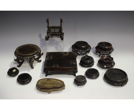 A collection of thirteen Chinese wood stands, late 19th century or later, including a small circular stand with pierced apron